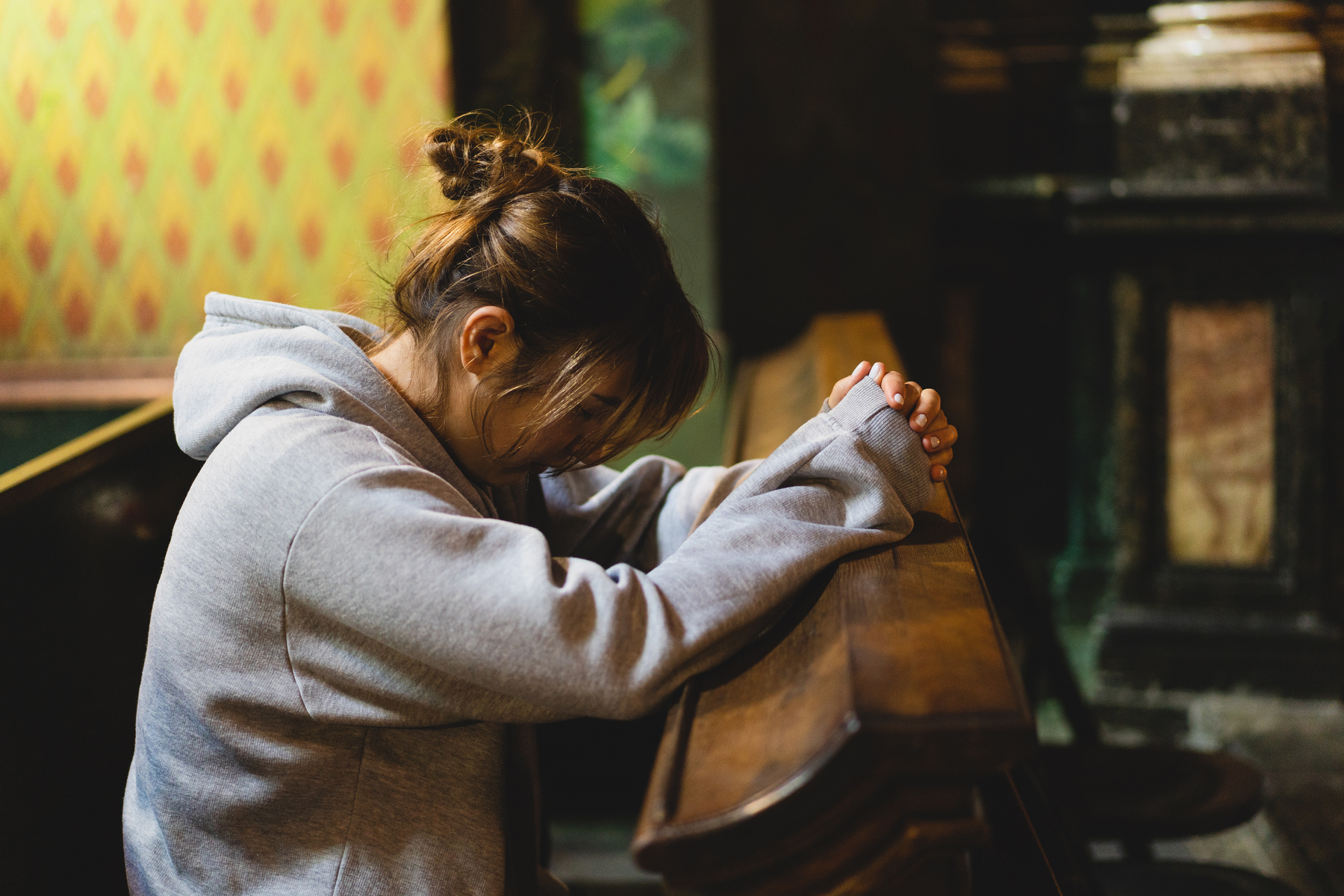 Woman praying on her knees in an ancient Catholic temple to God